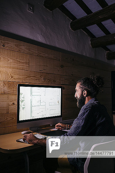 Young architect working hard on a new project at home at night