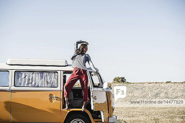 Hübsche Frau auf einer Autoreise mit ihrem Wohnwagen  jubelt  genießt die Freiheit
