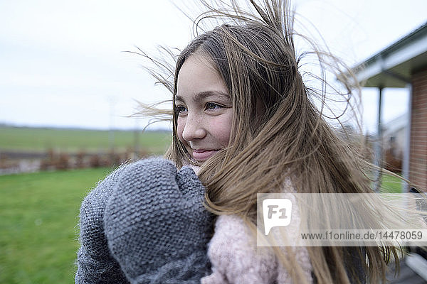 Porträt eines lächelnden Mädchens mit wehendem Haar im Winter