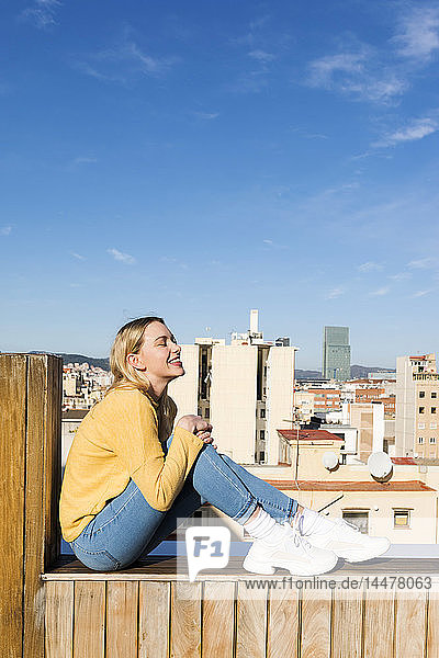 Junge Frau entspannt sich auf einer städtischen Dachterrasse