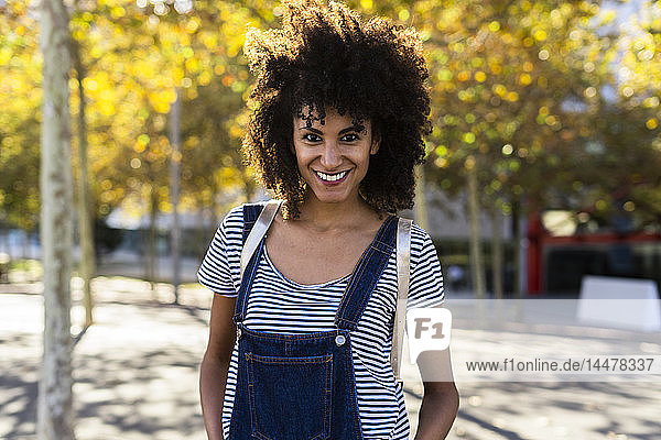 Porträt einer lächelnden Frau  stehend in einem Park