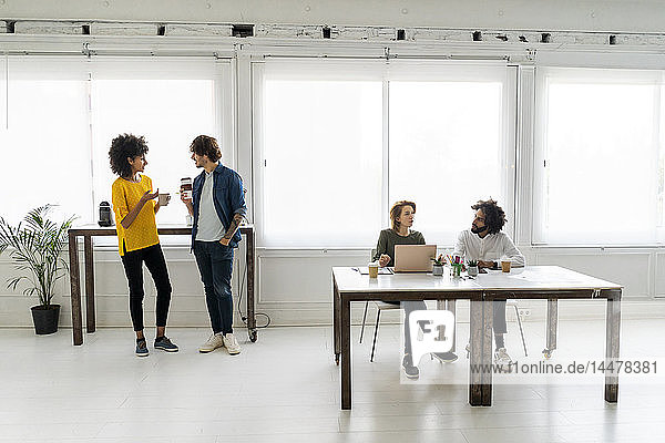 Junge Geschäftsleute arbeiten im Coworking Space zusammen
