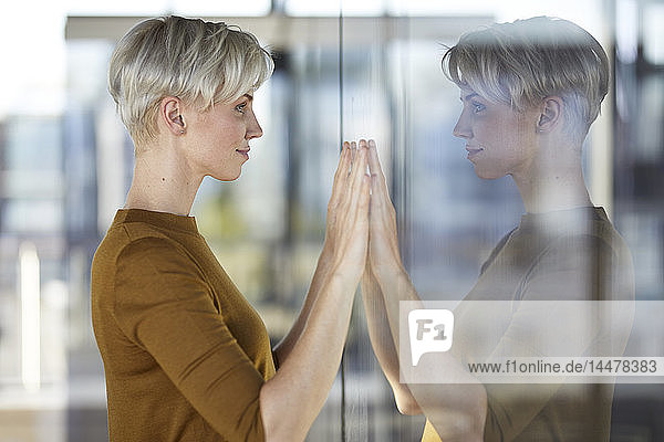 Frau spiegelt sich im Fenster