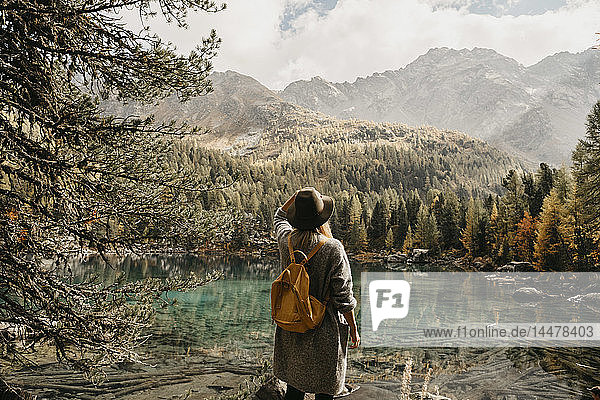 Schweiz  Engadin  Frau auf einer Wanderung am Seeufer in einer Berglandschaft stehend