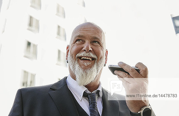 Elegant businessman in the city  using smartphone