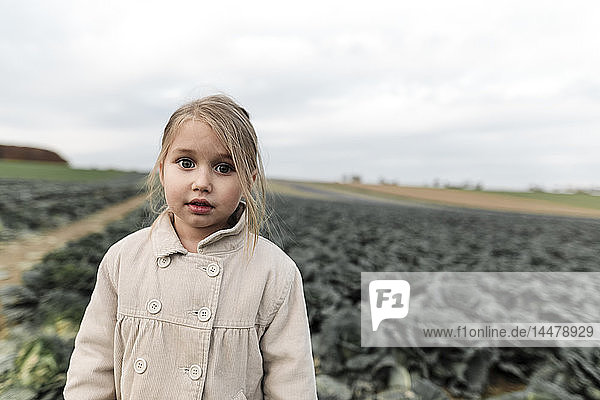 Portrait of a girl standing on a cabbage field