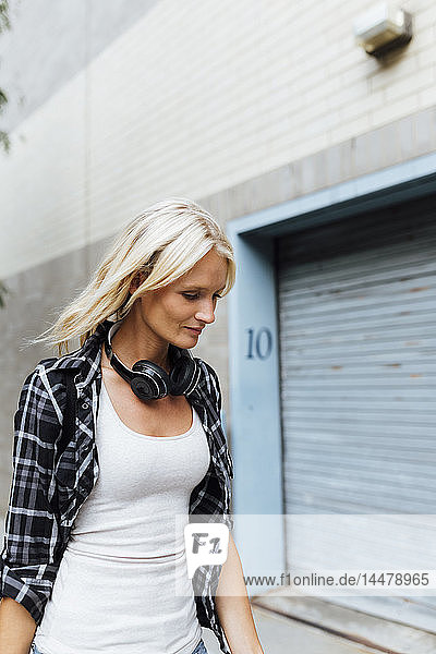 USA  New York City  Brooklyn  junge Frau mit Kopfhörern in der Stadt unterwegs