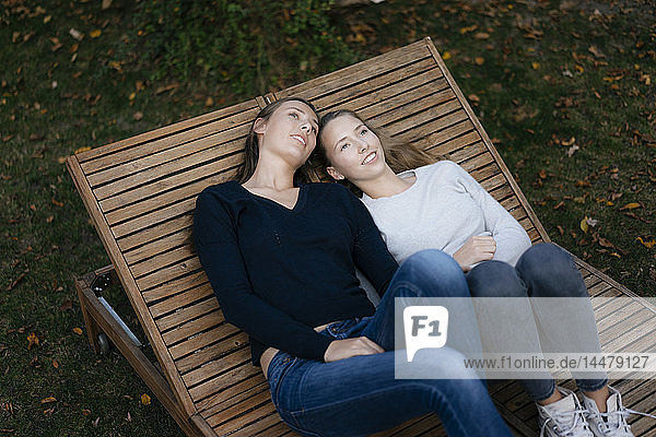 Zwei liebevolle  nachdenkliche Teenager-Mädchen ruhen sich auf einer Sonnenliege aus