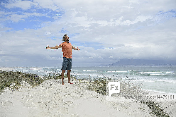 South Africa man raising arms at Bloubergstrand