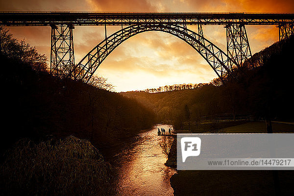 Deutschland Müngstener Brücke zwischen Solingen und Remscheid mit Wupper in der Dämmerung im Vordergrund
