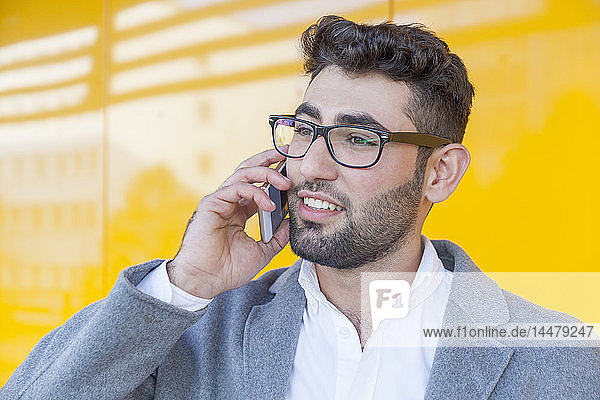 Porträt eines bärtigen jungen Geschäftsmannes am Telefon