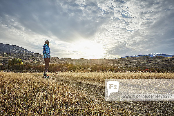 Chile  Valle Chacabuco  Parque Nacional Patagonia  woman standing in steppe landscape at sunset
