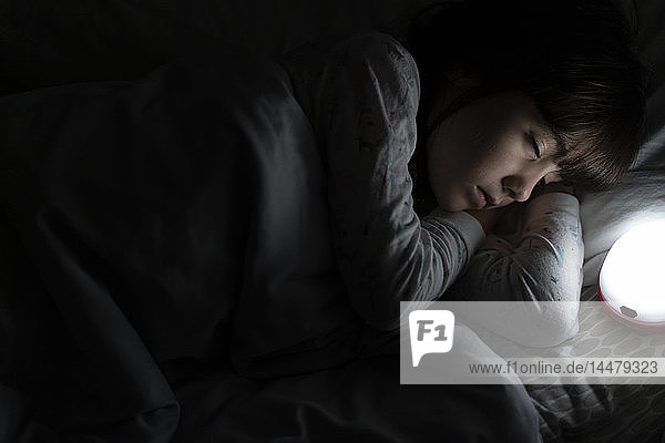 Girl sleeping in bed at night with night light