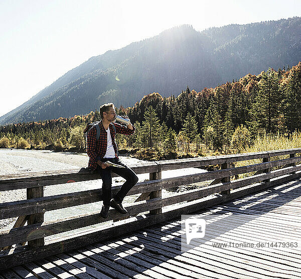 Österreich  Alpen  Mann auf Wanderung mit Rast auf einer Brücke