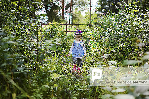 Little girl wearing knitted hat and denim shirt in nature