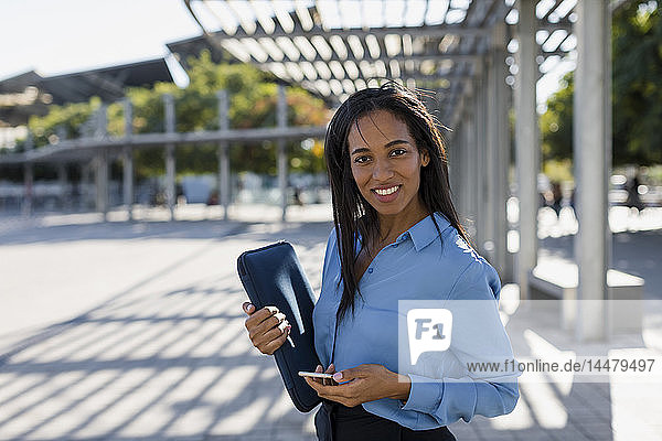 Geschäftsfrau mit Smartphone  Laptop-Tasche