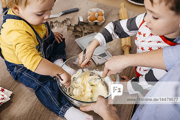 Mother and children preparing dough together