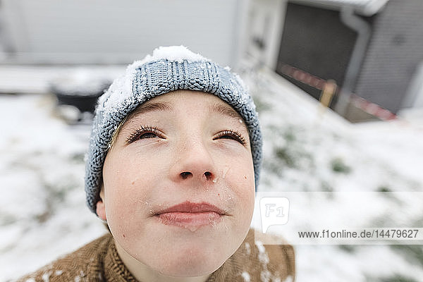 Boy looking up on falling snow