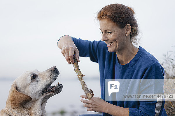 Deutschland  Hamburg  glückliche Frau kuschelt mit Hund am Elbufer