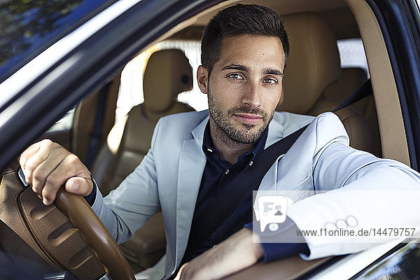 Erfolgreicher junger Geschäftsmann fährt in seinem Auto