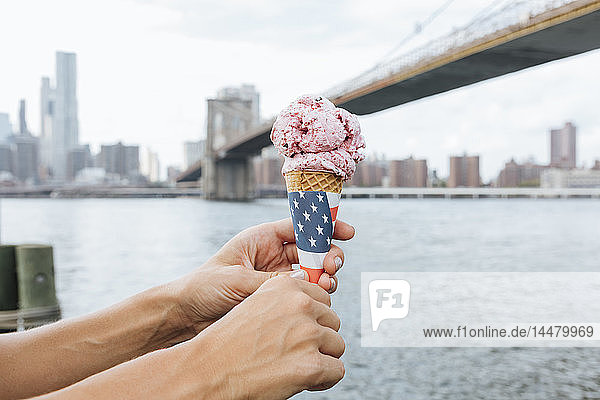 USA  New York City  Brooklyn  Nahaufnahme einer Frau am Hafen mit einer Eistüte in der Hand