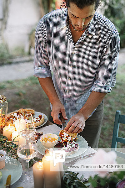 Man arranging a romantic candlelight meal outdoors