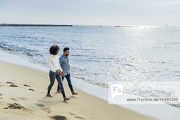 Spanien  Barcelona  Paar  das barfuss am Strand spazieren geht