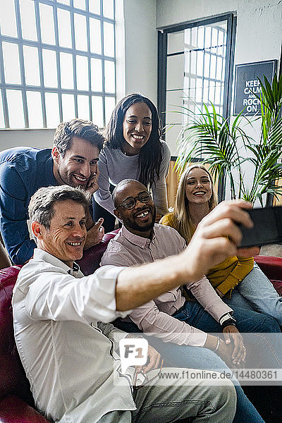 Happy business team taking a selfie in loft office