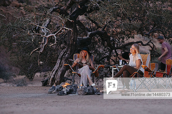 Namibia  Freunde sitzen am Lagerfeuer und spielen Gitarre
