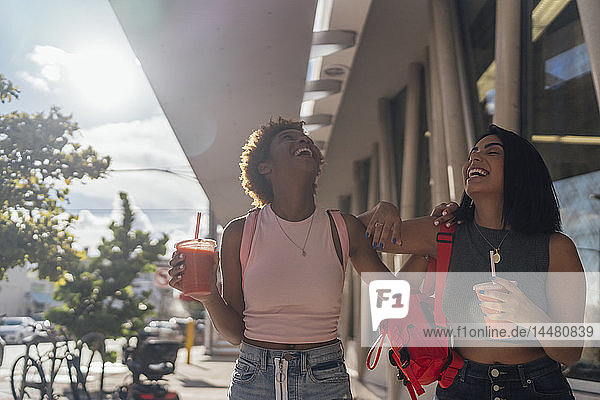 USA  Florida  Miami Beach  zwei glückliche Freundinnen bei einem Erfrischungsgetränk in der Stadt