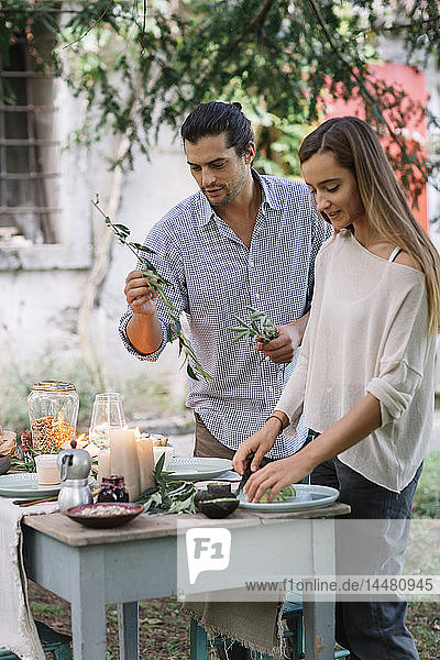 Couple preparing a romantic candlelight meal outdoors