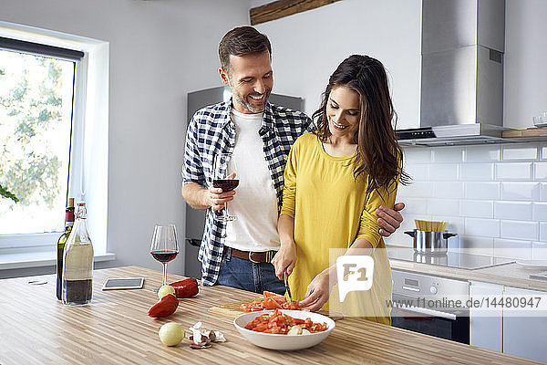 Liebespaar in der Küche  bereitet gemeinsam Spaghetti zu  trinkt Rotwein