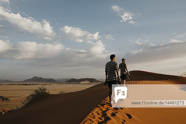 Namibia  Namib desert  Namib-Naukluft National Park  Sossusvlei  two men walking on Elim Dune at sunset