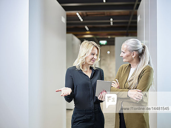 Zwei Geschäftsfrauen teilen sich ein Tablett im Büro