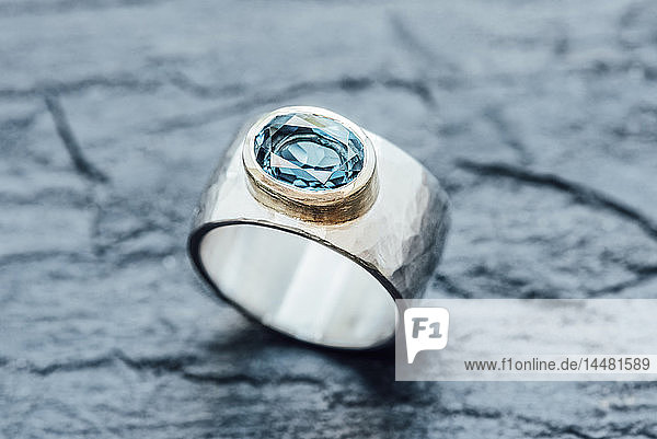 Silberring mit Topas in Goldfassung auf Schiefer