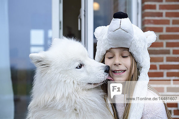Porträt eines Mädchens auf der Terrasse mit ihrem weißen Hund