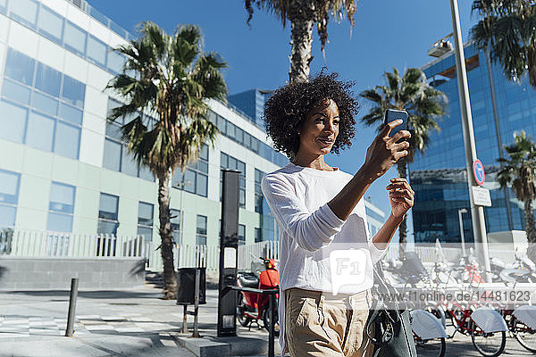 Young casual businesswoman in the city  using smartphone