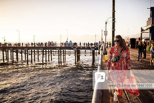 USA  Kalifornien  Santa Monica  lächelnde Frau geht auf dem Pier