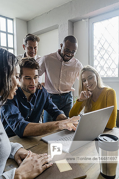 Geschäftsteam benutzt Laptop während einer Besprechung im Büro