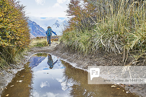 Argentinien Patagonien El Chalten Junge läuft in Pfütze am Cerro Torre im Nationalpark Los Glaciares
