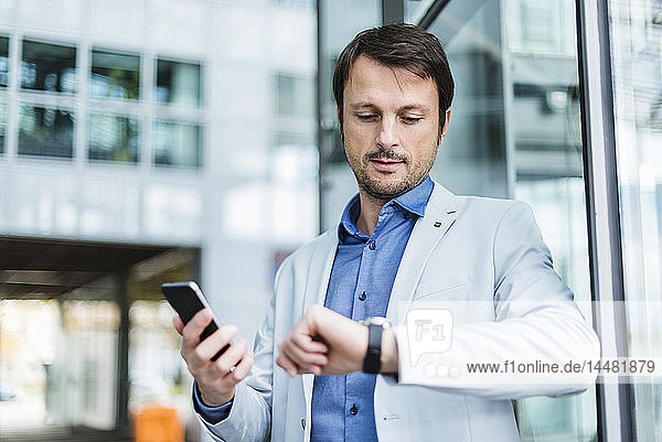 Portrait of a businessman checkin time  using smartphone
