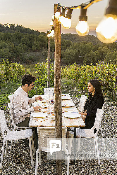 Italien  Toskana  Siena  junges Paar beim Abendessen in einem Weinberg