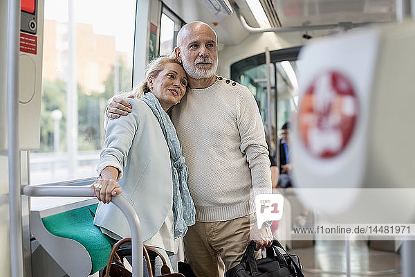 Affectionate senior couple standing in a tram