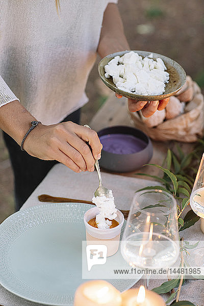 Close-up of woman preparing a romantic candlelight meal outdoors