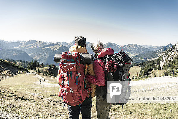 Austria  Tyrol  rear view of couple on a hiking trip in the mountains enjoying the view