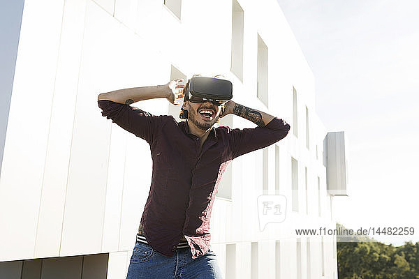 Mann auf einer Dachterrasse  Spielen mit VR-Brille