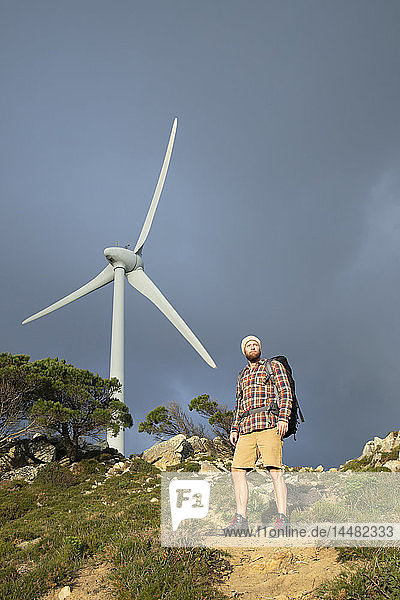 Spanien  Andalusien  Tarifa  Mann auf Wanderung auf einem Wanderweg stehend mit Windrad im Hintergrund