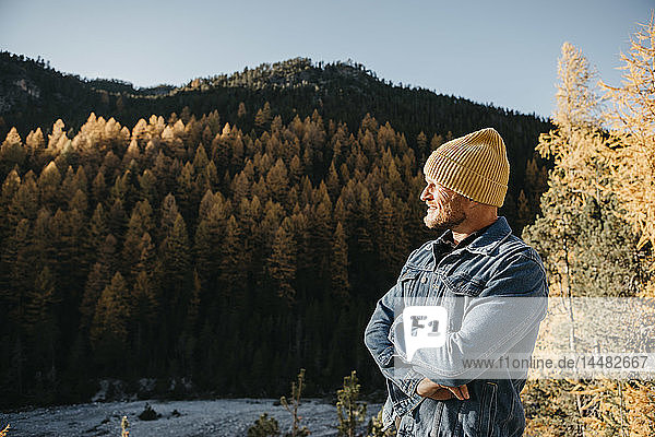 Mature man travelling through Switzerland  standing in nature