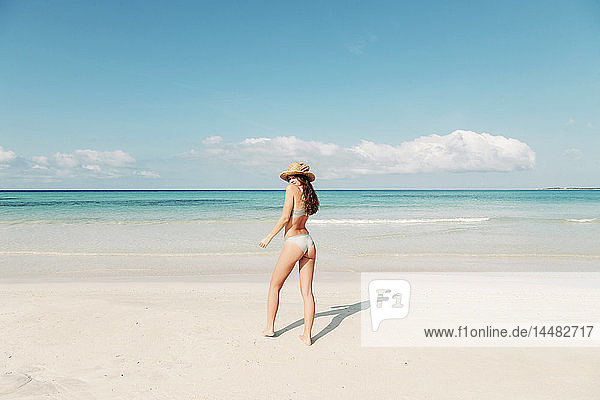 Spanien  Mallorca  Rückansicht einer jungen Frau im Urlaub am Strand stehend