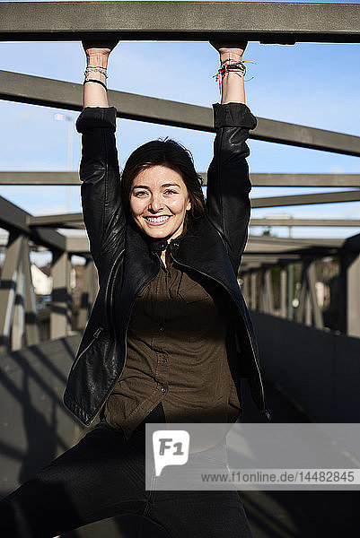 Porträt einer lächelnden jungen Frau auf einer Brücke